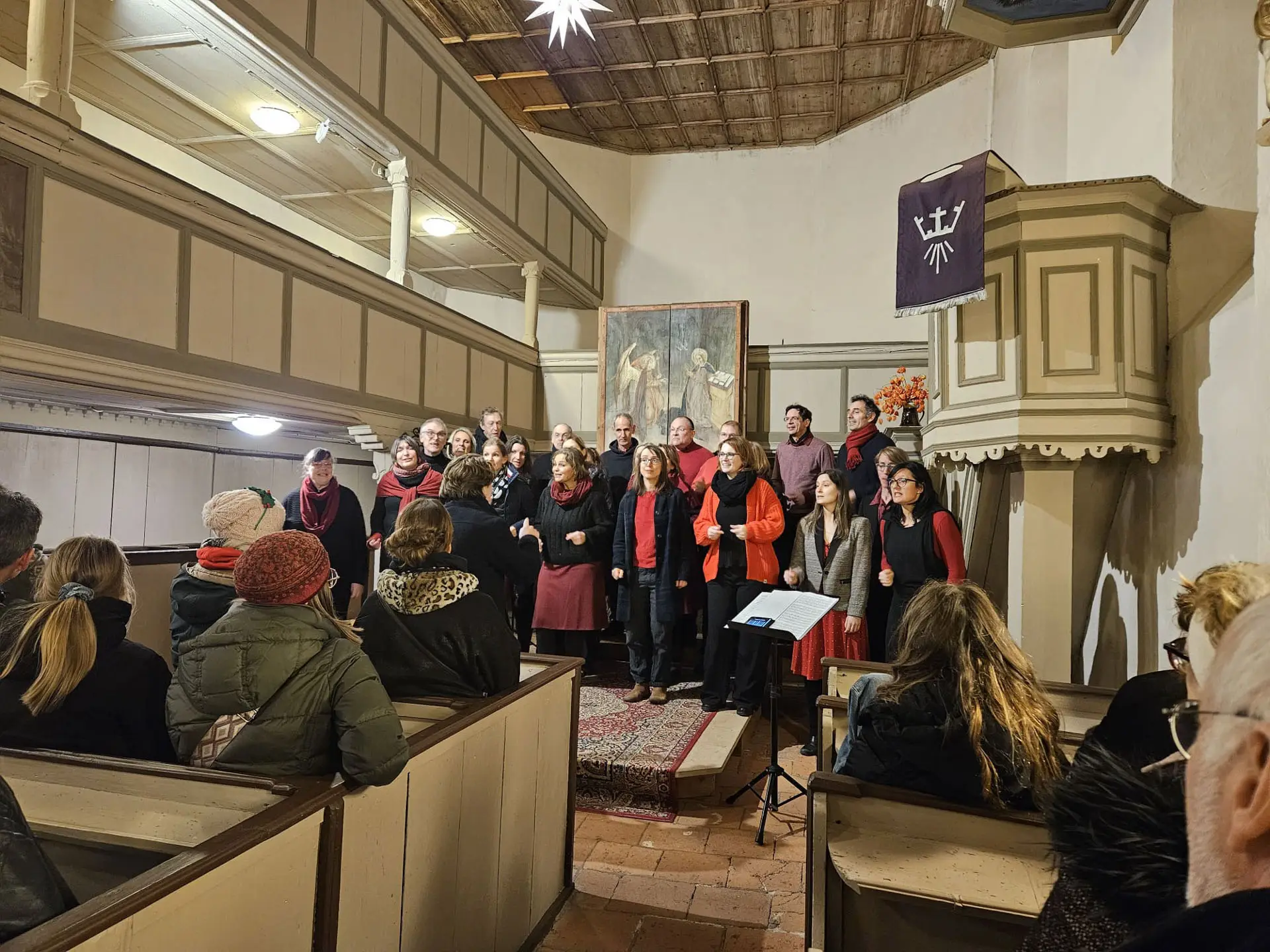 Der Jazzchor inTune singt in einer kleinen Kirche vor sitzendem Publikum.